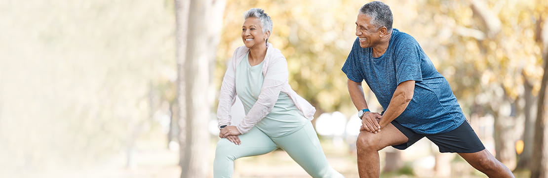 Senior couple stretching in the park